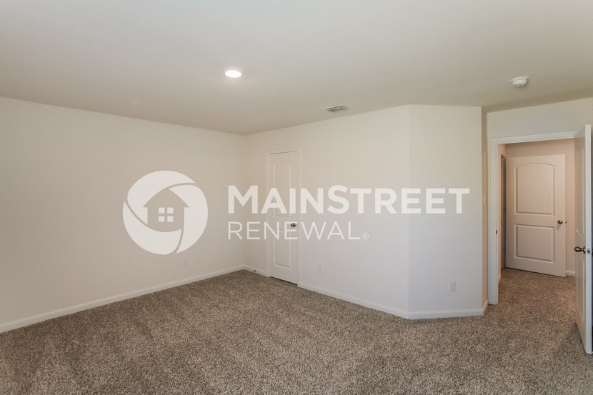 a bedroom with a carpeted floor and a door