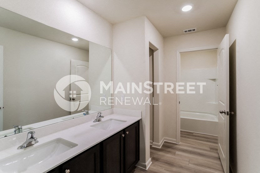 a bathroom with two sinks and a shower and a large mirror