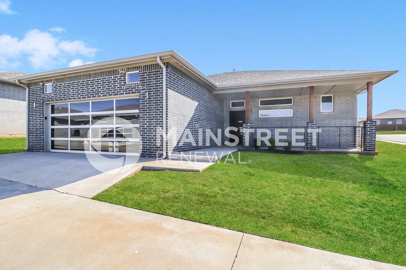 a renovated house with a garage and a lawn