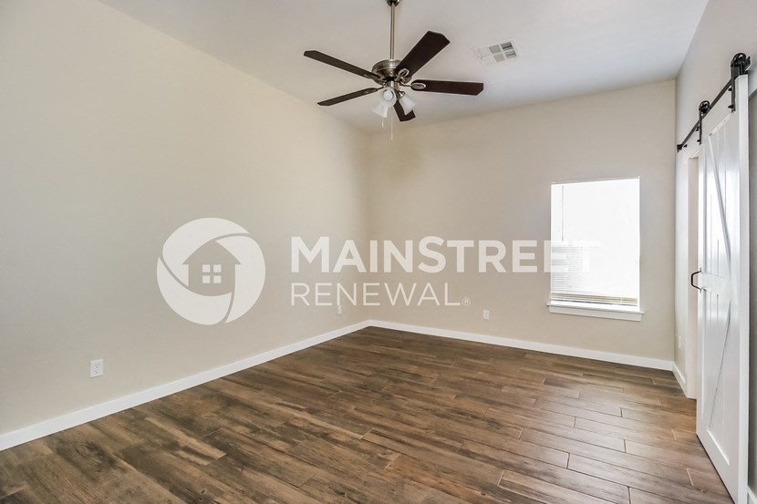renovated living room with hardwood flooring and a ceiling fan