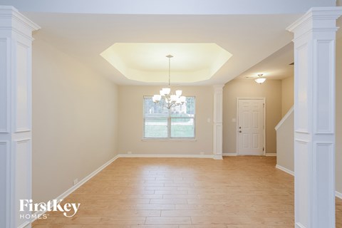 an empty dining room with wood floors and a window