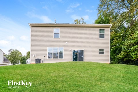 the back of a house on a grassy hill