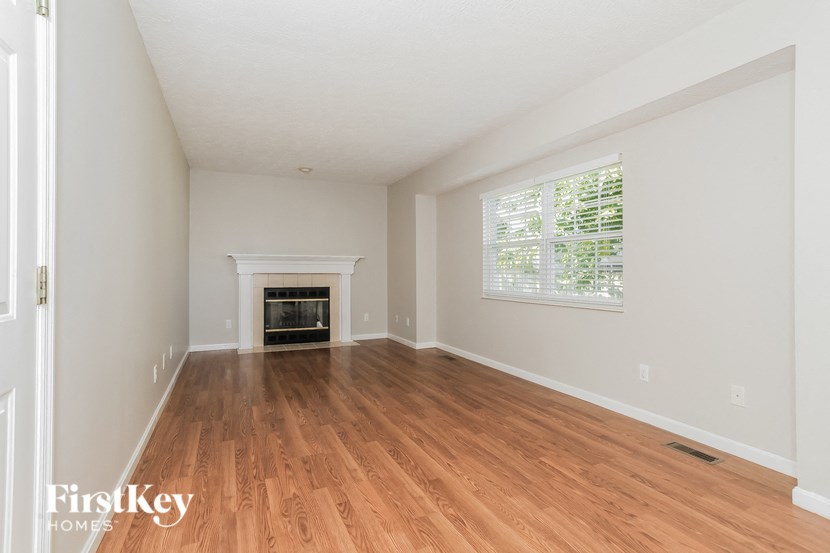 A room with a fireplace and wooden floors.