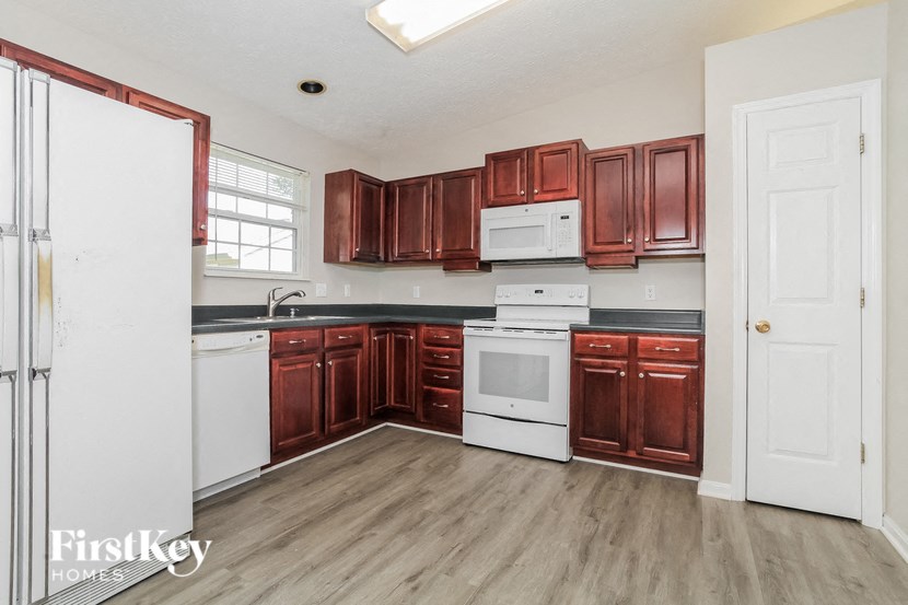 A kitchen with brown cabinets and a white fridge.