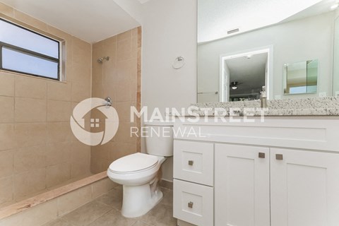 a bathroom with a toilet and a sink and a mirror