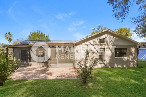 a small house with a garage and a grass yard