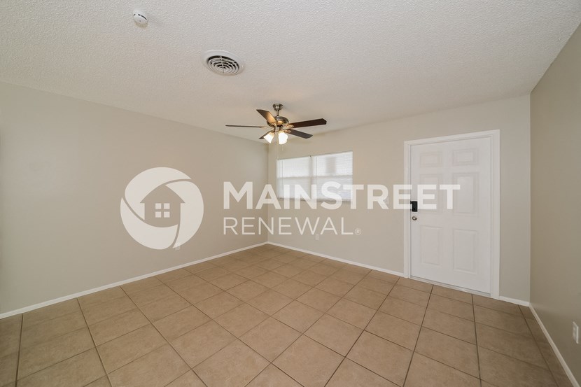 a room with a tile floor and a ceiling fan