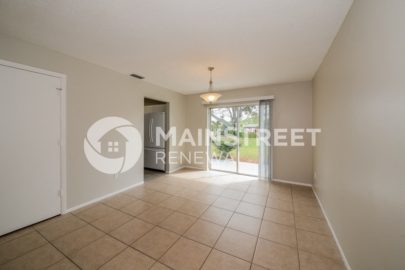 a large empty living room with a door to a patio