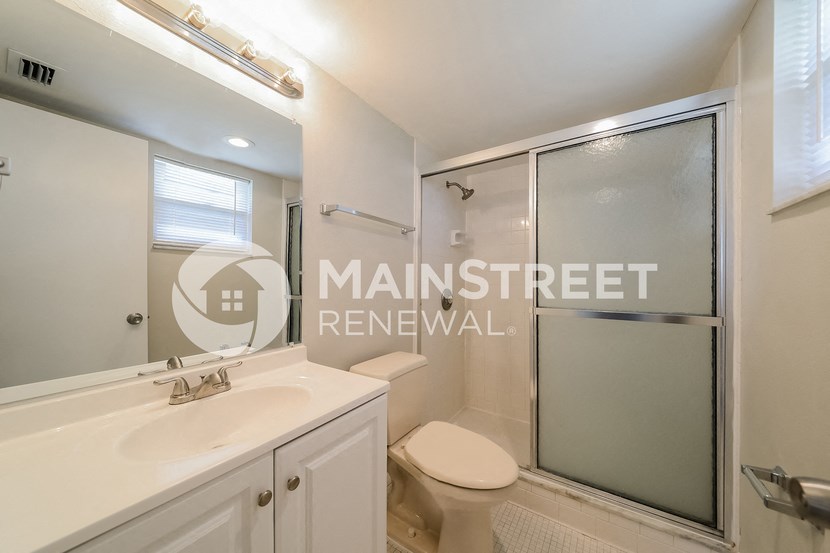 a bathroom with a toilet and a sink and a shower