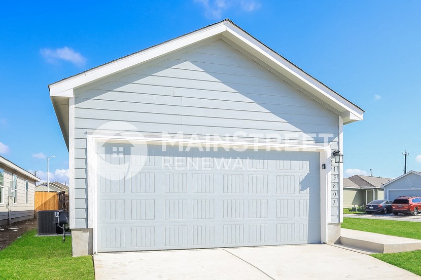a garage with a white garage door on the side of a house