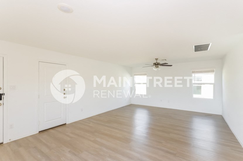 a renovated living room with hardwood floors and white walls