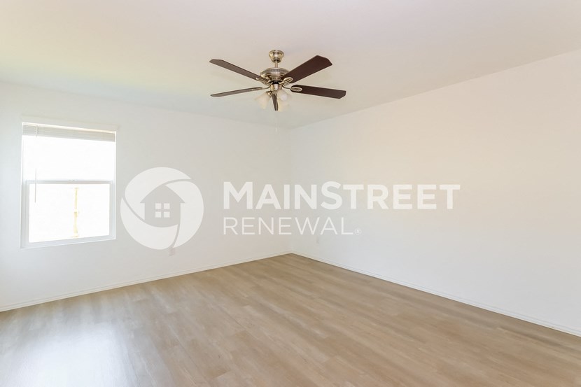 a living room with a ceiling fan and a window