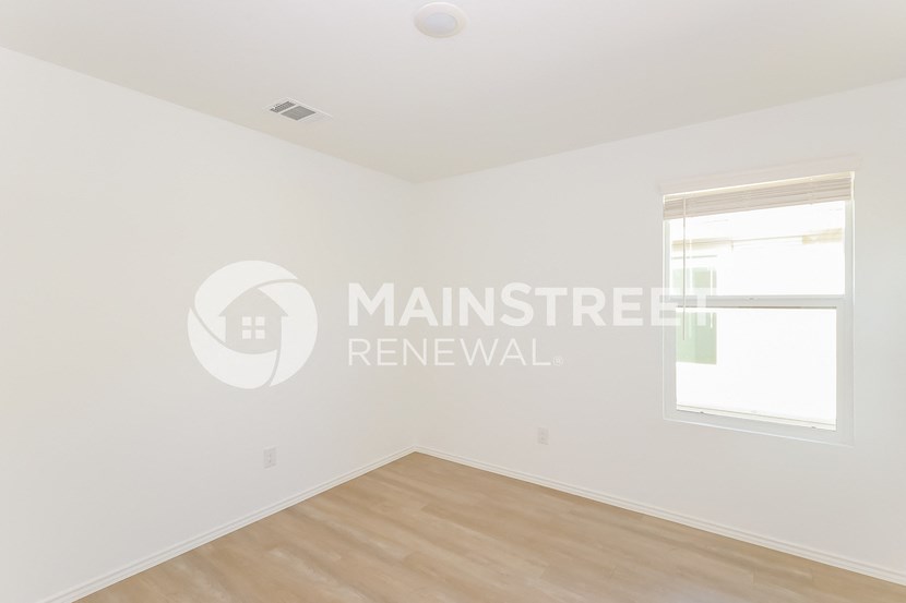 a bedroom apartment with a hardwood floor and white walls