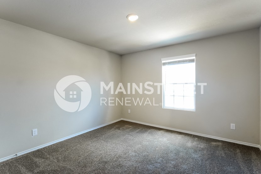 a bedroom with a carpeted floor and a window