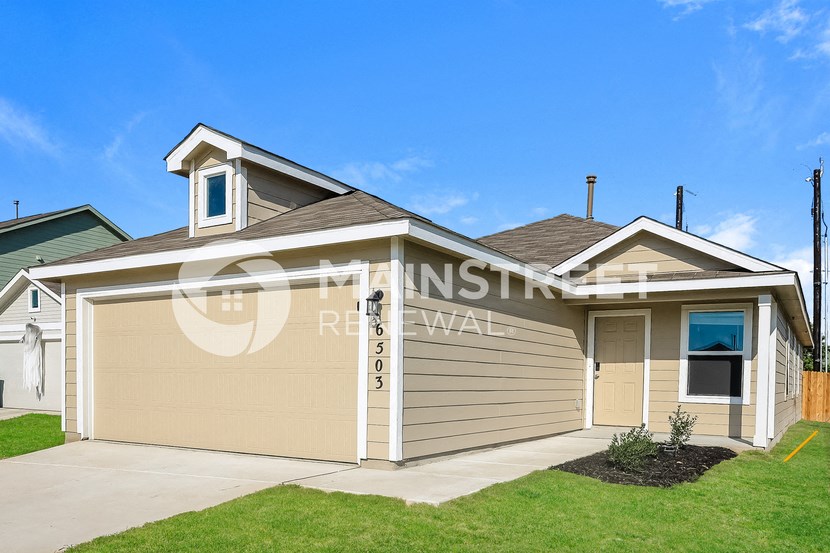 front view of a house with a garage and lawn