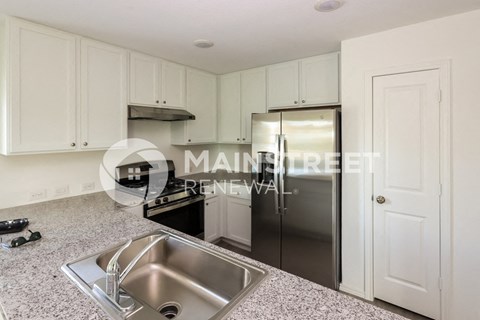 a renovated kitchen with stainless steel appliances and granite counter tops