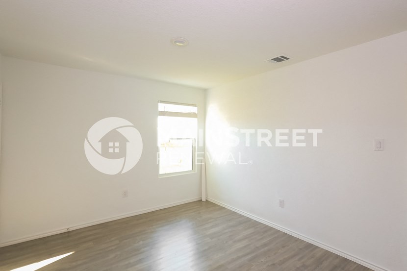 an empty living room with white walls and a window