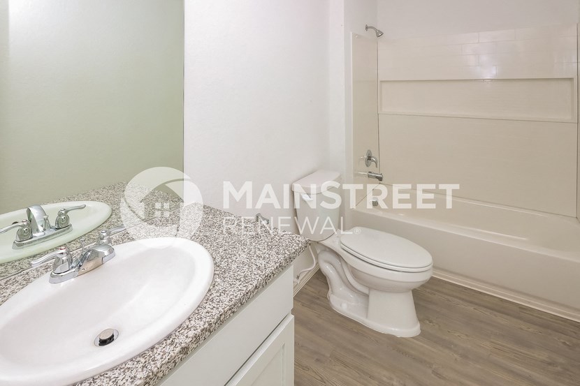 a bathroom with a toilet and a sink and a tub