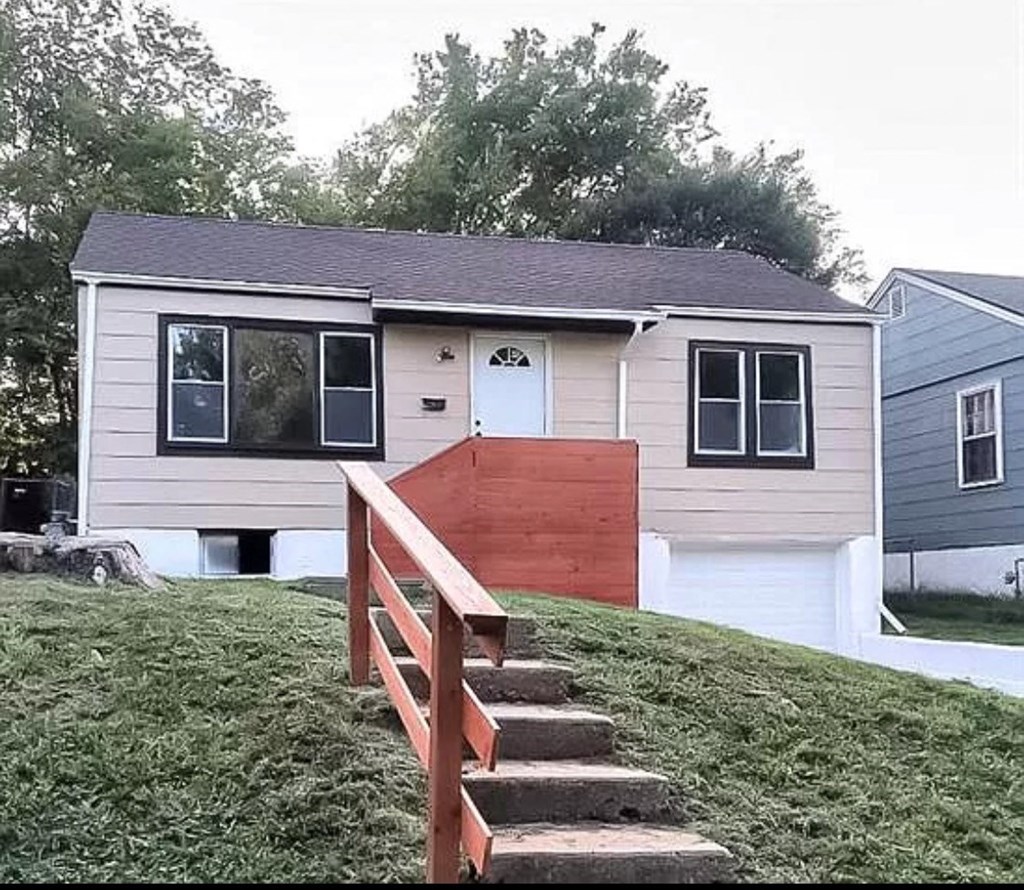 a small house on a hill with stairs