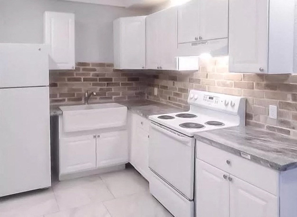 a white kitchen with white appliances and white cabinets