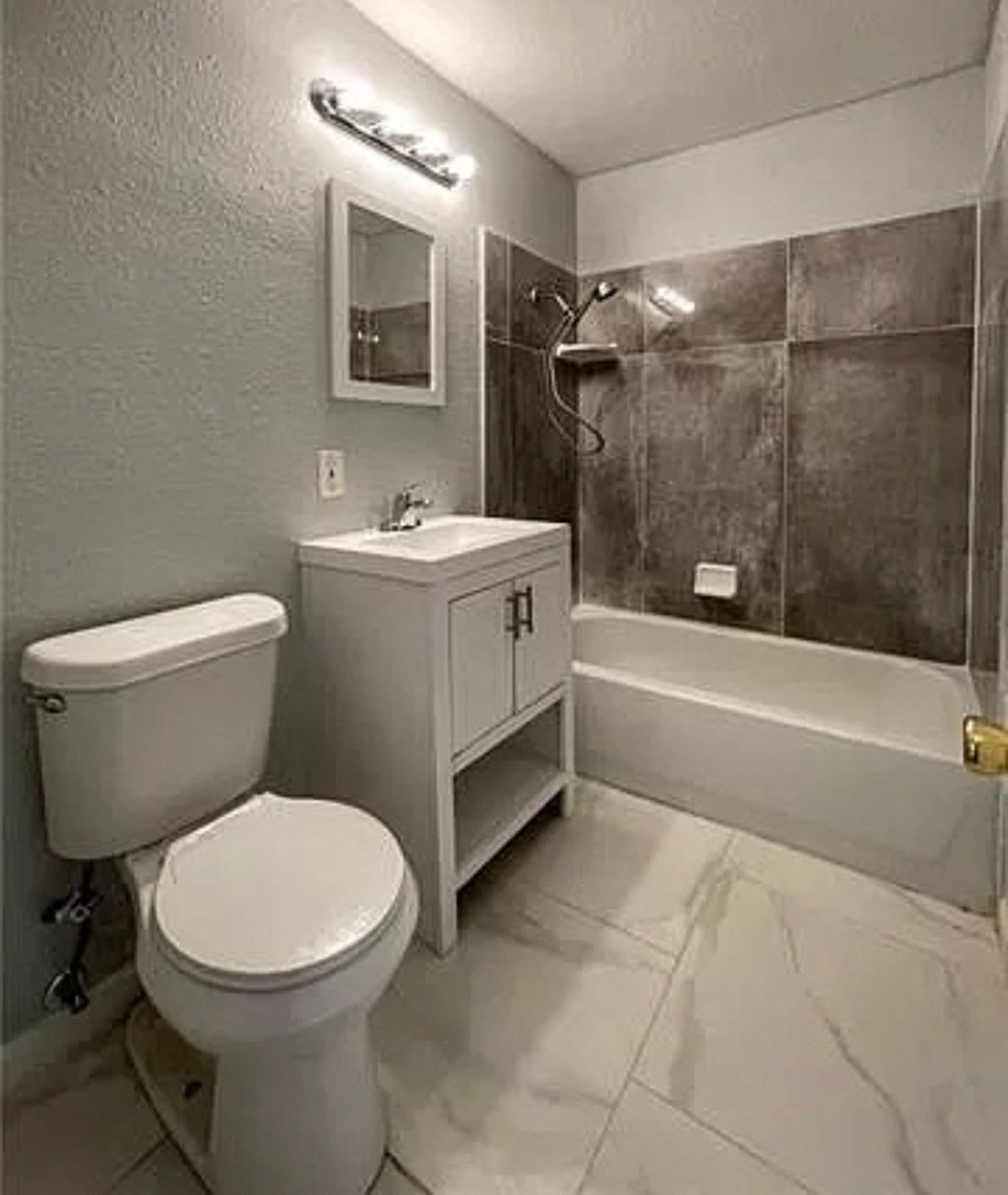 a bathroom with a toilet and a sink and a shower