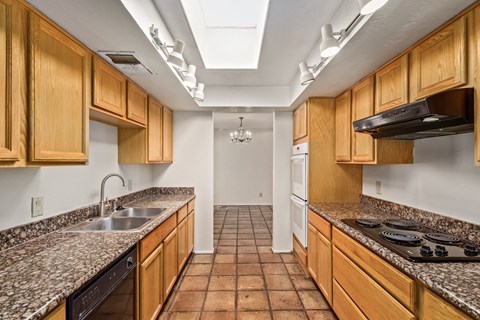 a kitchen with granite counter tops and wooden cabinets