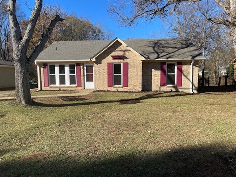 A house with red shutters and a grey roof.