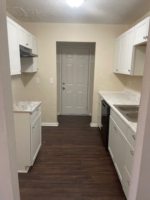 A kitchen with white cabinets and a white door.