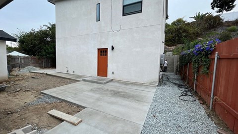 the back of a white house with a orange door
