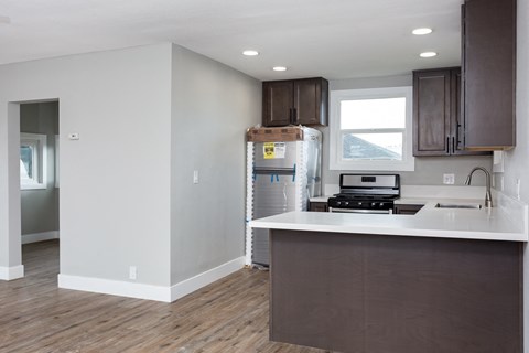 A kitchen with brown cabinets and a white counter.