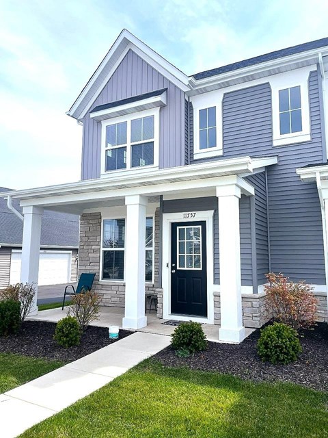 A house with a front porch and a black door.