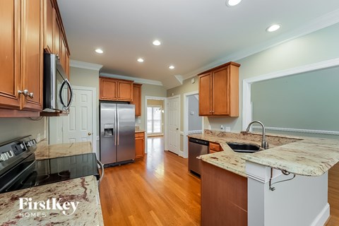 A kitchen with wooden cabinets and a granite countertop.