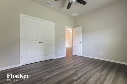 a bedroom with two closets and a ceiling fan