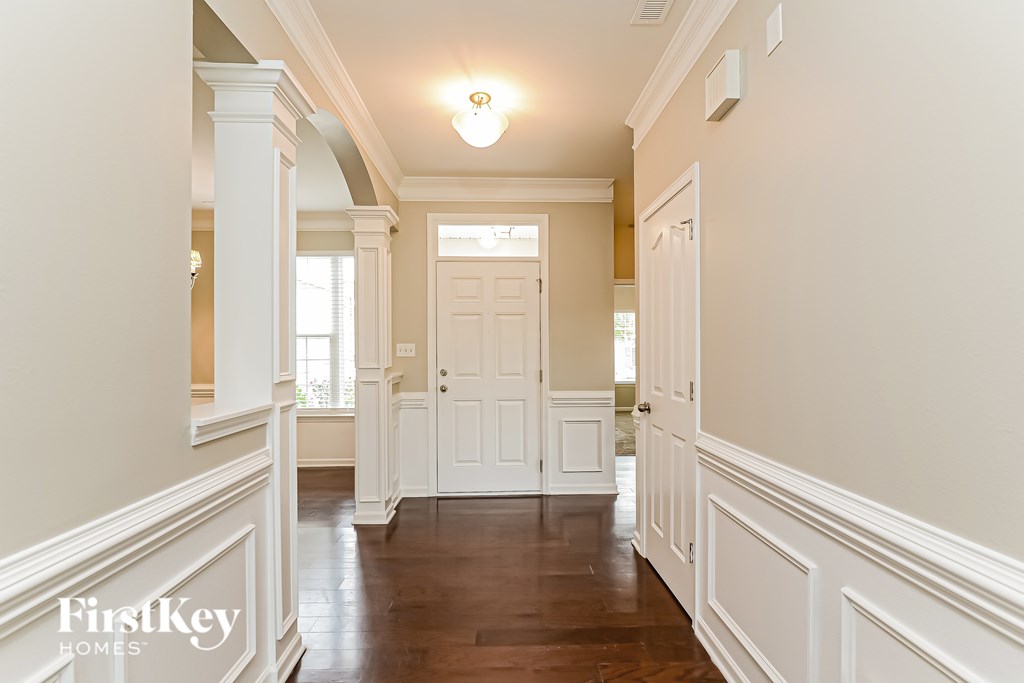 A hallway with a white door and a light on the ceiling.