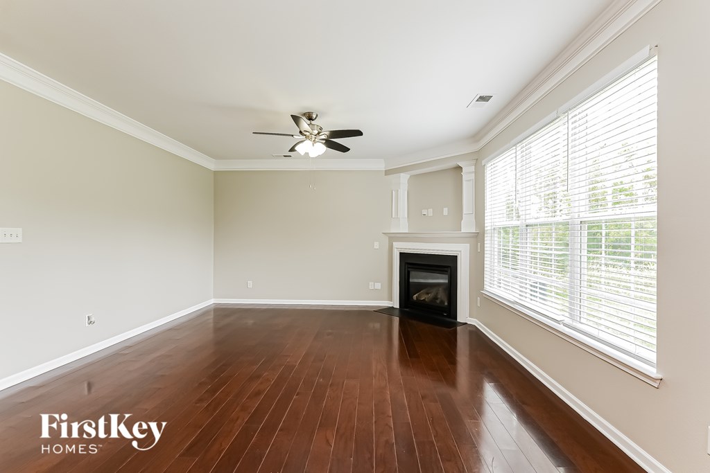 A spacious room with a fireplace and a ceiling fan.