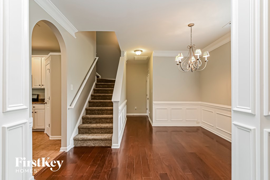 A chandelier hangs over a staircase in a home.