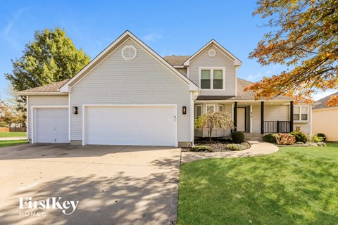 a white house with a white garage door and a lawn