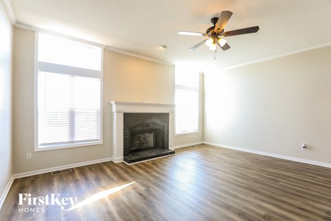 a living room with a fireplace and a ceiling fan