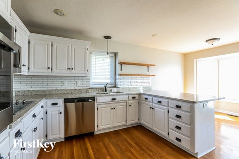 a kitchen with white cabinets and stainless steel appliances