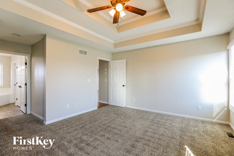 a living room with carpet and a ceiling fan