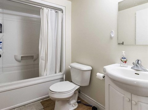 A white toilet sits next to a white sink in a bathroom.