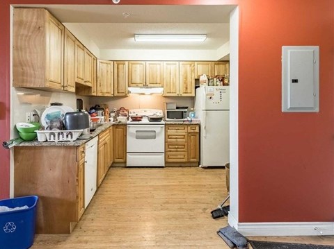 A kitchen with wooden cabinets and a white refrigerator.