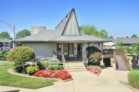 A small building with a green sign that says "Office" in front of it.