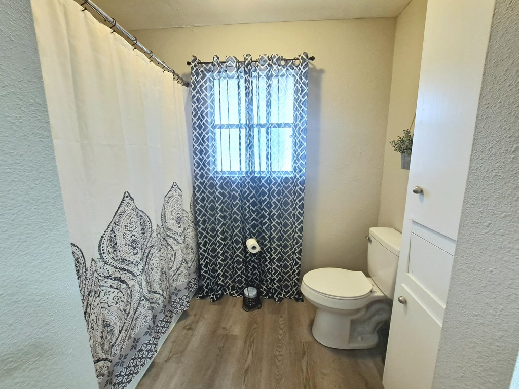 a bathroom with a toilet and a shower curtain