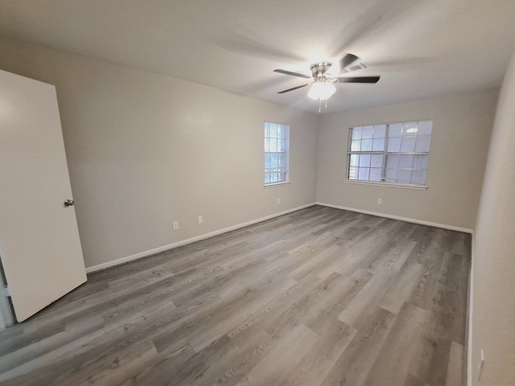 a bedroom with hardwood flooring and a ceiling fan