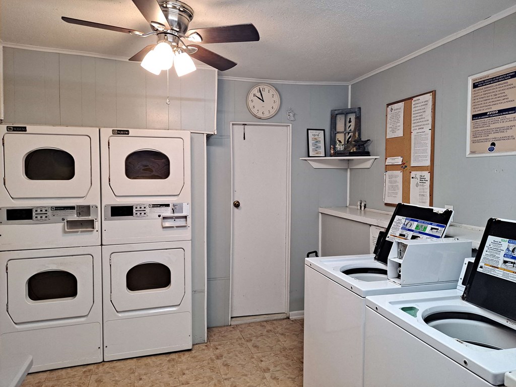 a laundry room with washer and dryer and a clock on the wall