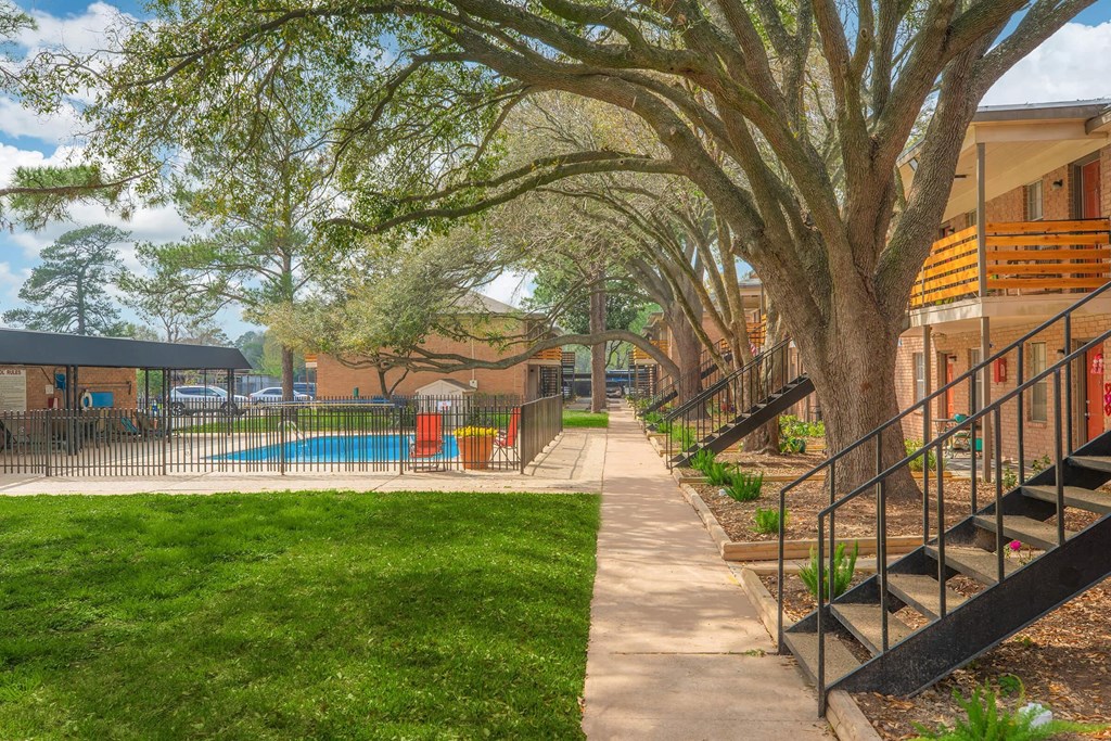 our apartments have a beautiful yard with trees and a pool