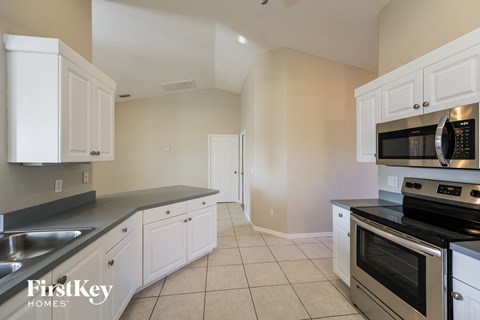 A kitchen with white cabinets and a stainless steel oven.