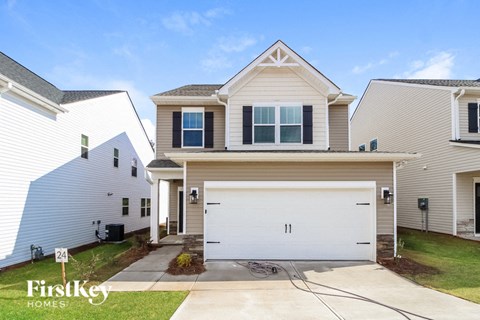 A house with a garage and a driveway in front of it.