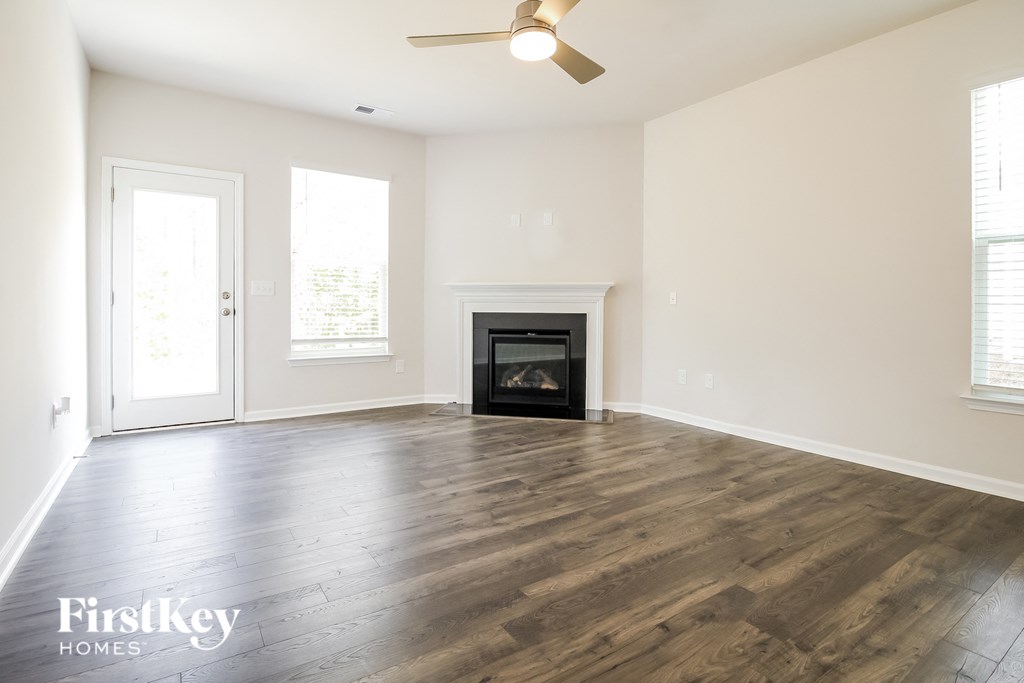 a living room with a fireplace and wooden floors